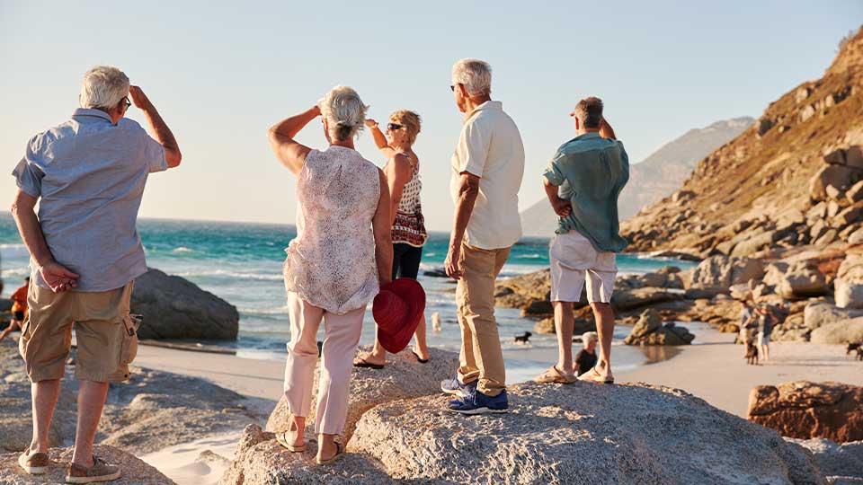 Group of Senior Friends Enjoying Beach Traveling Together