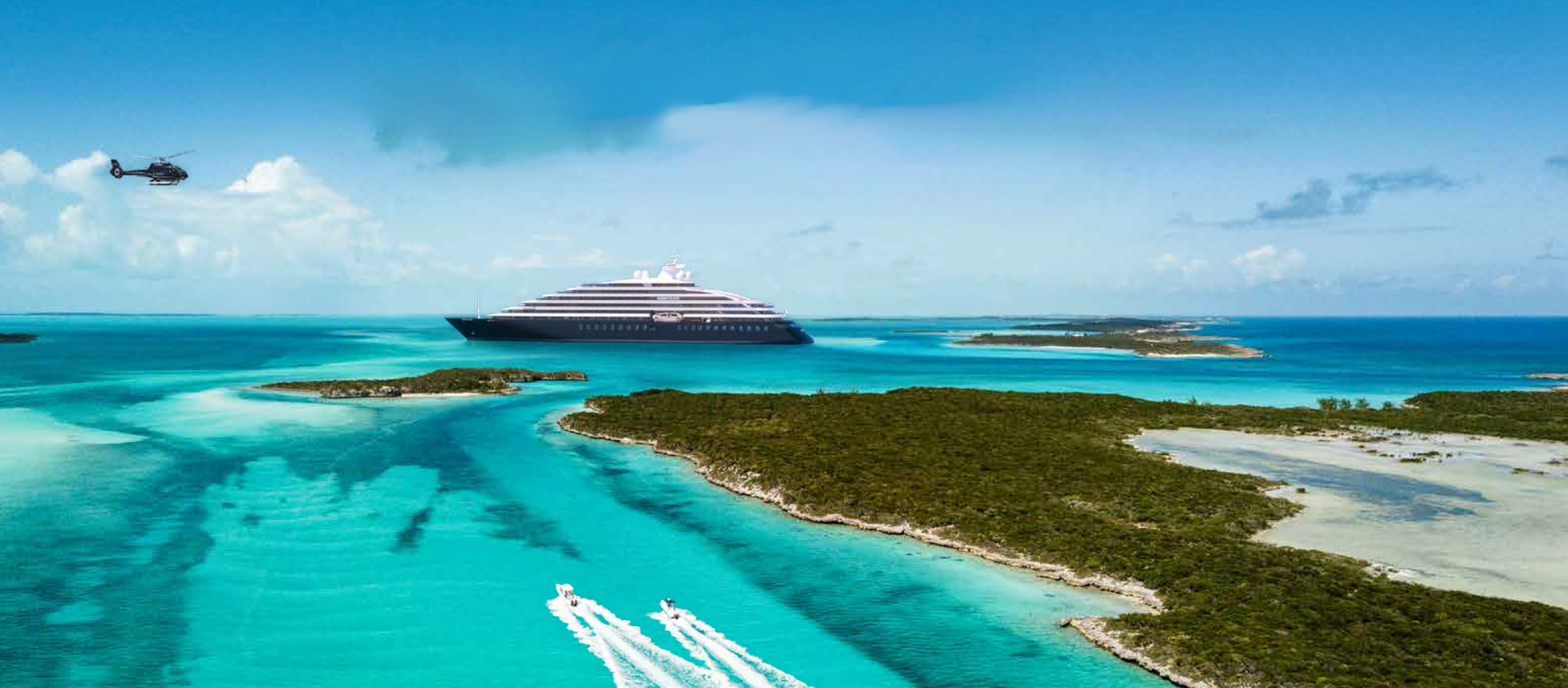 Scenic Eclipse at sea in the Caribbean with a helicopter flying nearby.